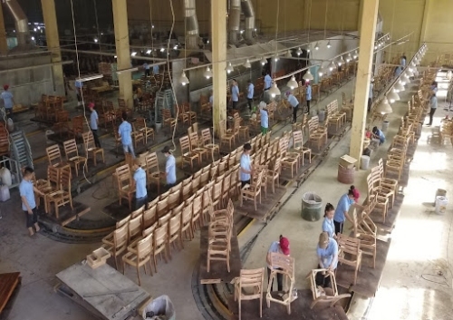 Công nhân đang hoàn thiện sản phẩm bàn ghế gỗ trong nhà máy tại thị xã Thuận An, Bình Dương. Ảnh: Hawa.